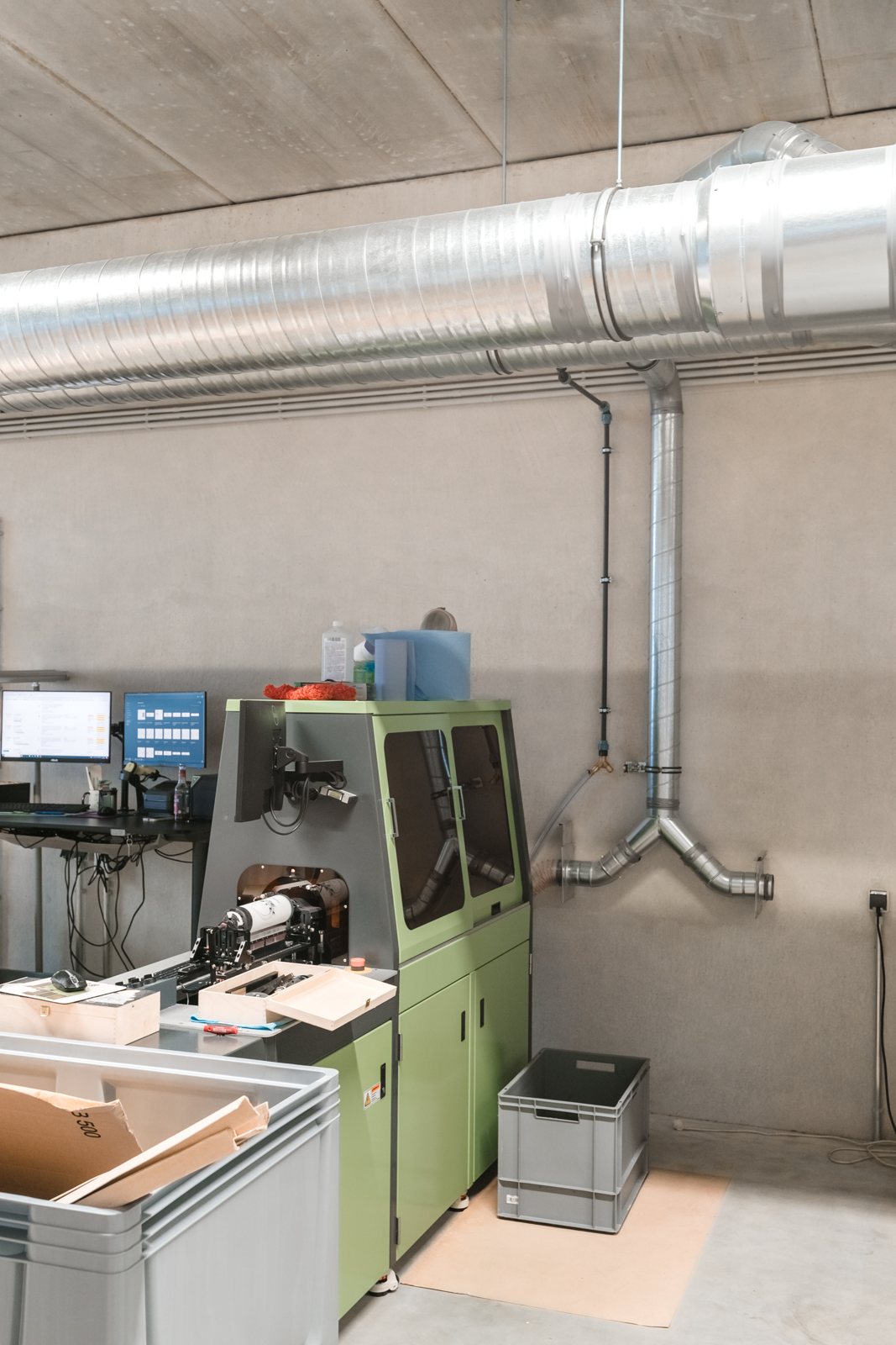 Maschinenarbeitsplatz mit Bildschirm und vorbereiteter Ware in der Produktion